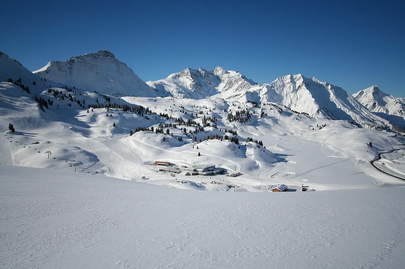 Verschneite Hochfläche mit Liften und Gipfeln im Skigebiet Warth-Schröcken